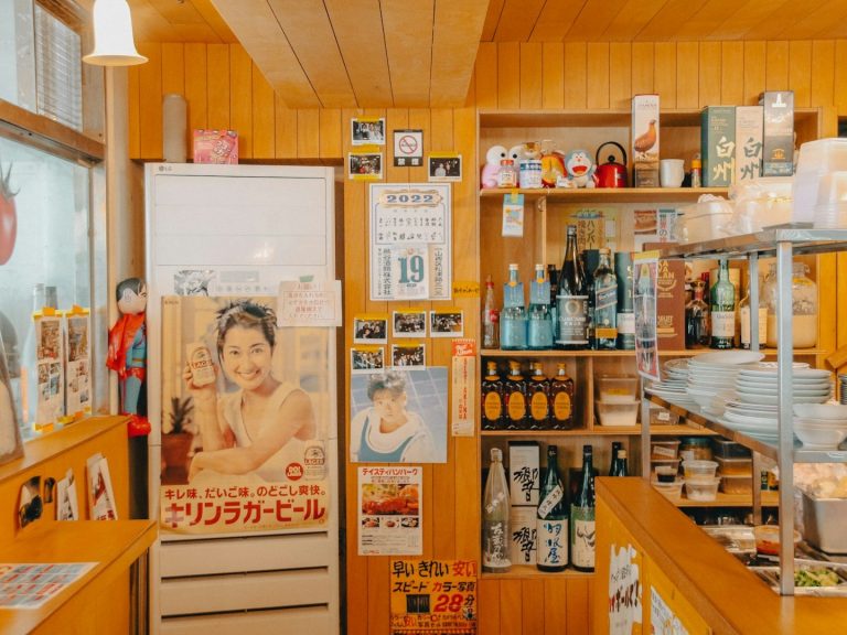 Interior de una tienda con estantes llenos de productos y carteles en las paredes.